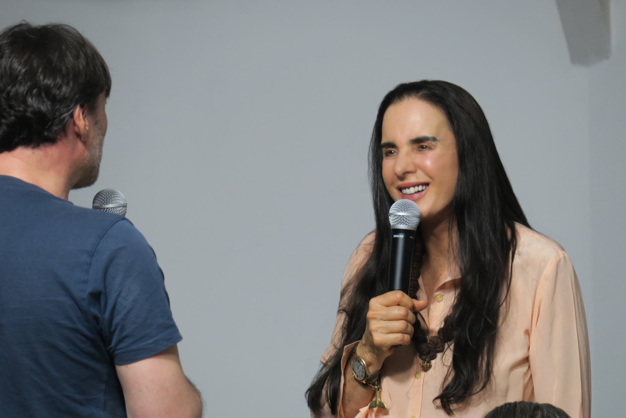 Isha Judd hablando con micrófono frente a un grupo en el Centro Unificación Uruguay